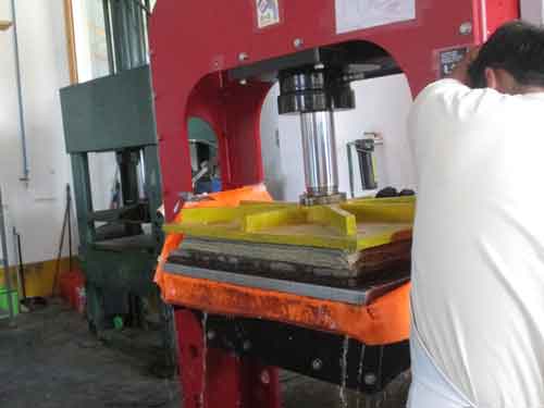 Now everything is ready for the press. In the past, this phase was carried out with a hand press. Today it is done with a modern hydraulic press. A large quantity of water comes out of the paper, like a small river